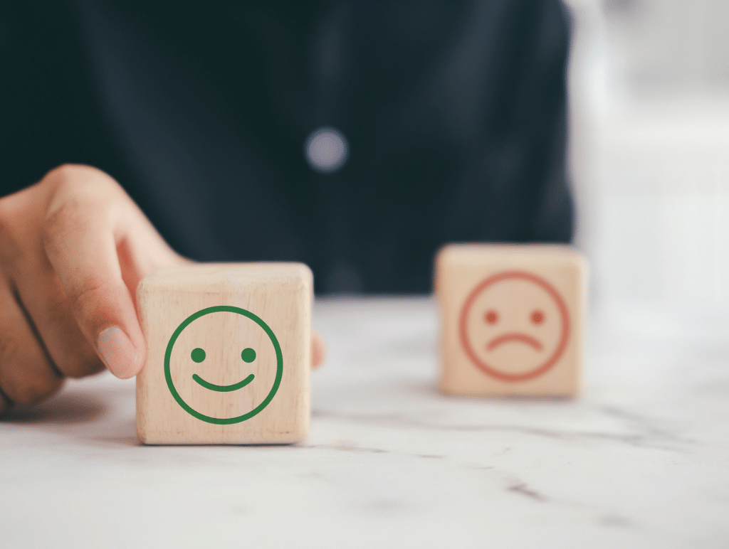 a happy face block in front of a sad face block to depict career transition Counseling